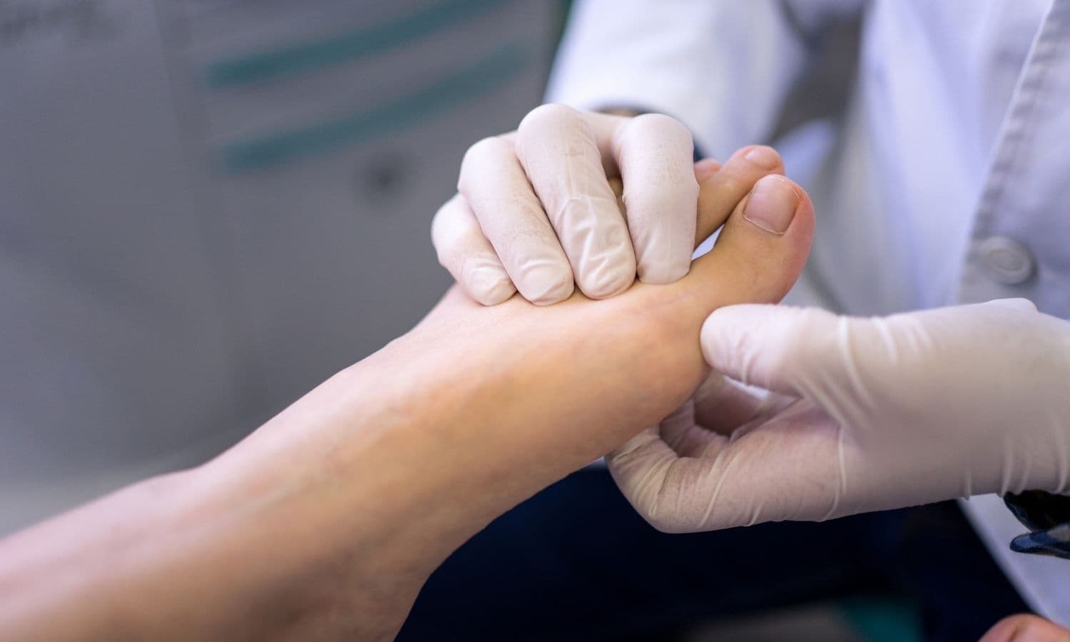 Mano professionale guantata che esamina con cura le dita di un piede